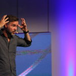 Antoni Lacinai håller en föreläsning om kundbemötande med en lila bakgrund